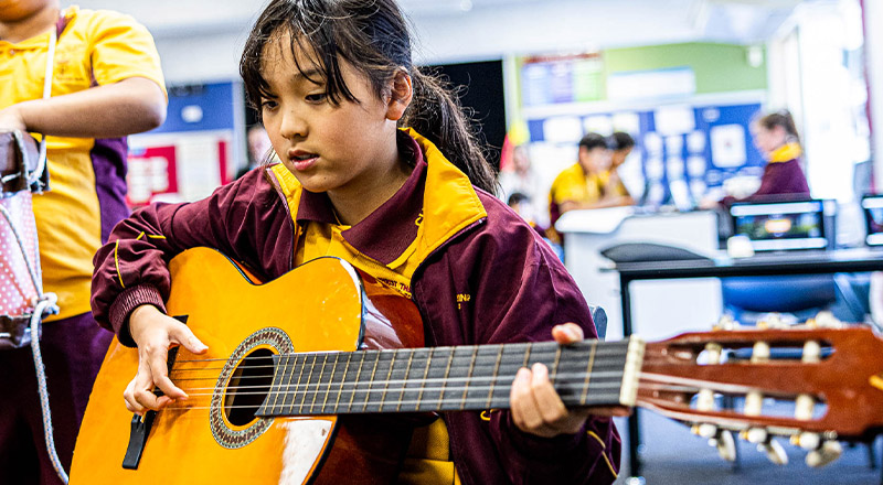 Student playing guitar at Christ the King Catholic Primary School North Rocks