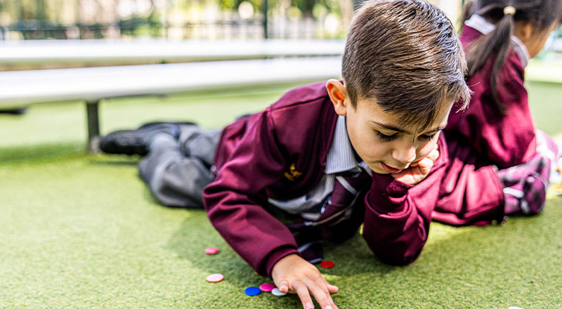 student laying on grass at Christ the King Catholic Primary School North Rocks