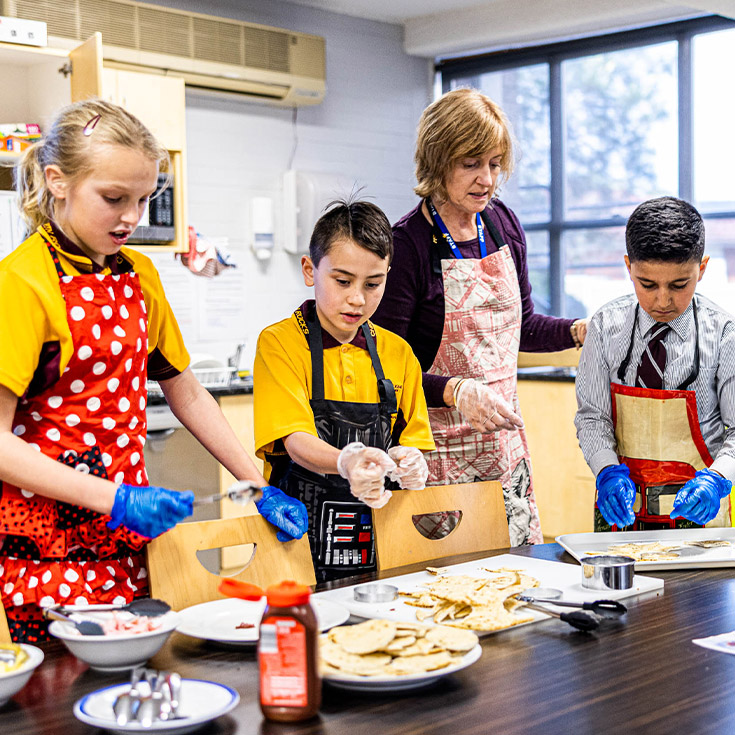 Teacher and three students cooking at Christ the King Catholic Primary School North Rocks